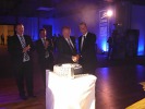 Krzysztof Polesiak, prezes Camso Polska S.A (od lewej) oraz Pierre Marcouiller, prezes i dyrektor generalny Camso podczas krojenia jubileuszowego tortu w kształcie opony